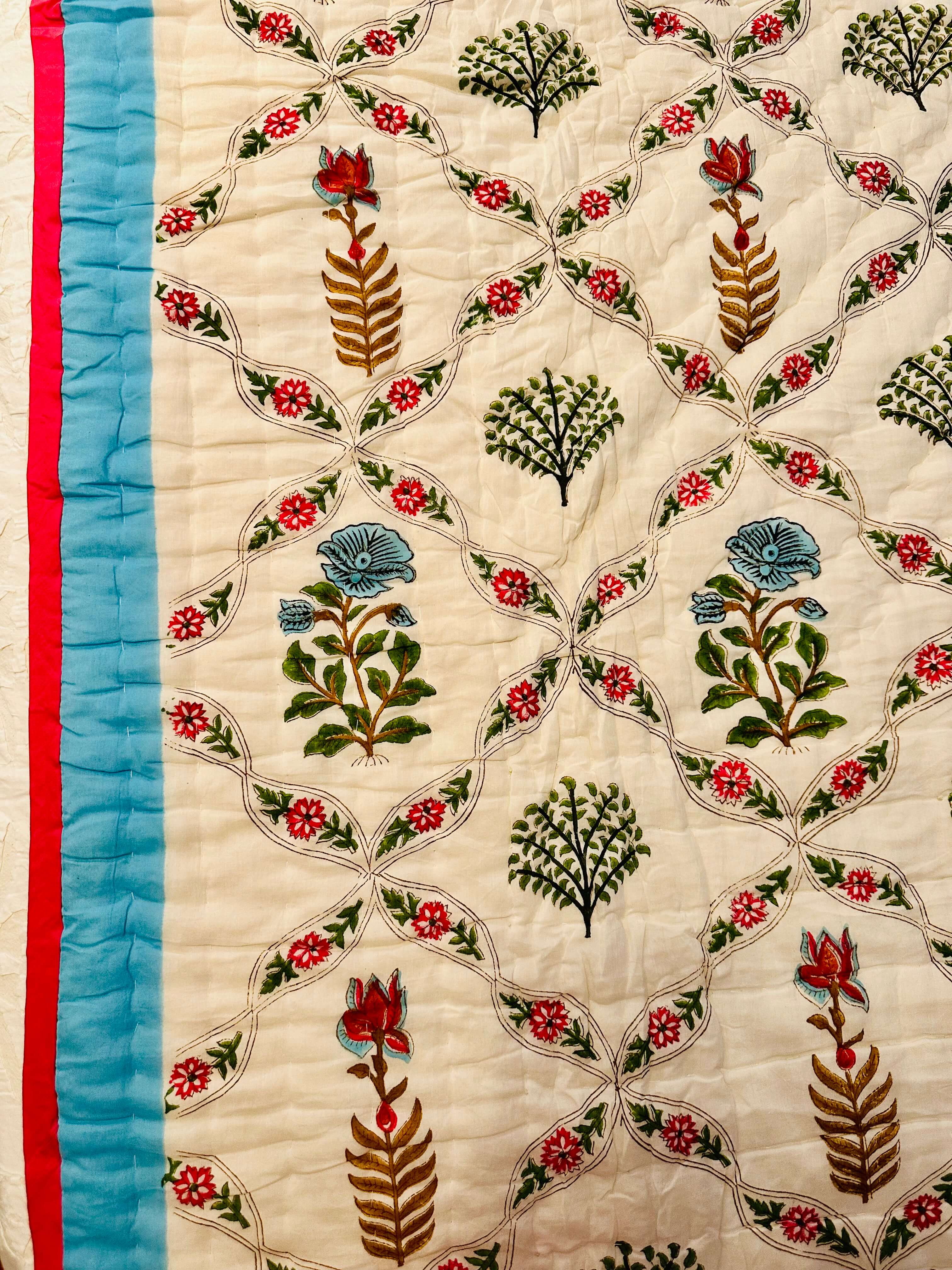 Soft blush pink quilt with delicate vine patterns, evoking a dreamy and romantic aesthetic.