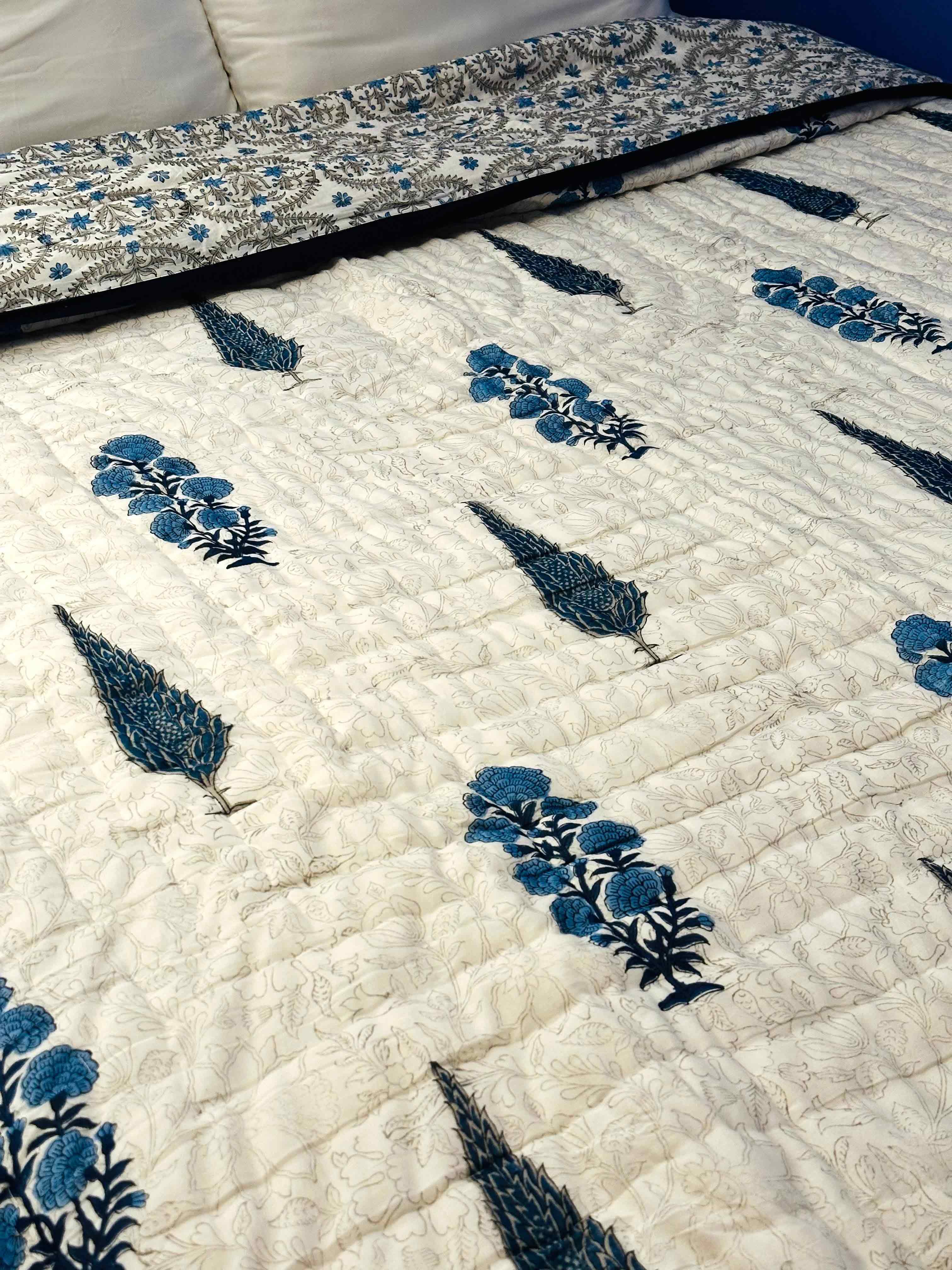 Angled side shot of Shadow Bloom quilt on bed